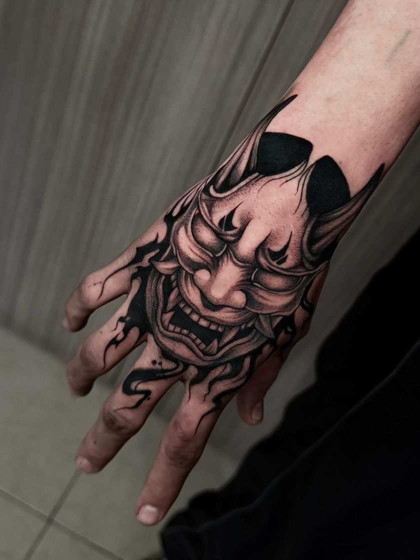 Máscara hannya sobre el dorso de la mano