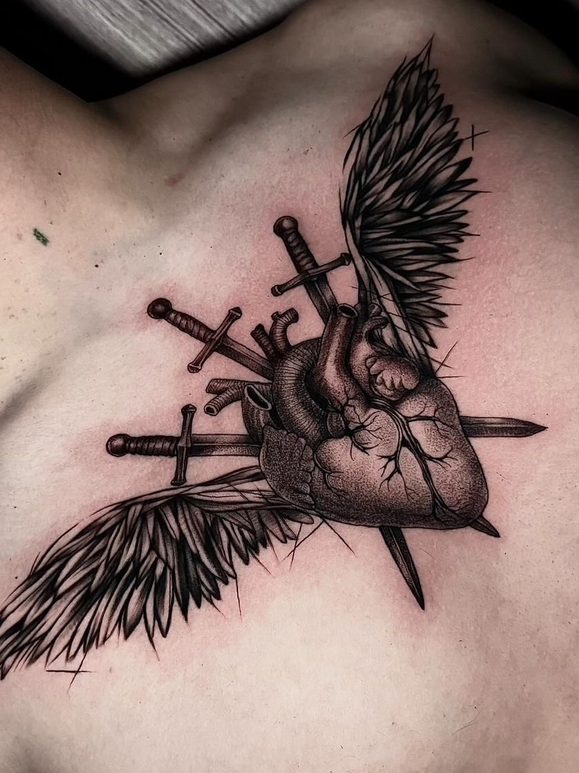 Corazón anatómico alado atravesado por espadas, en el pecho
