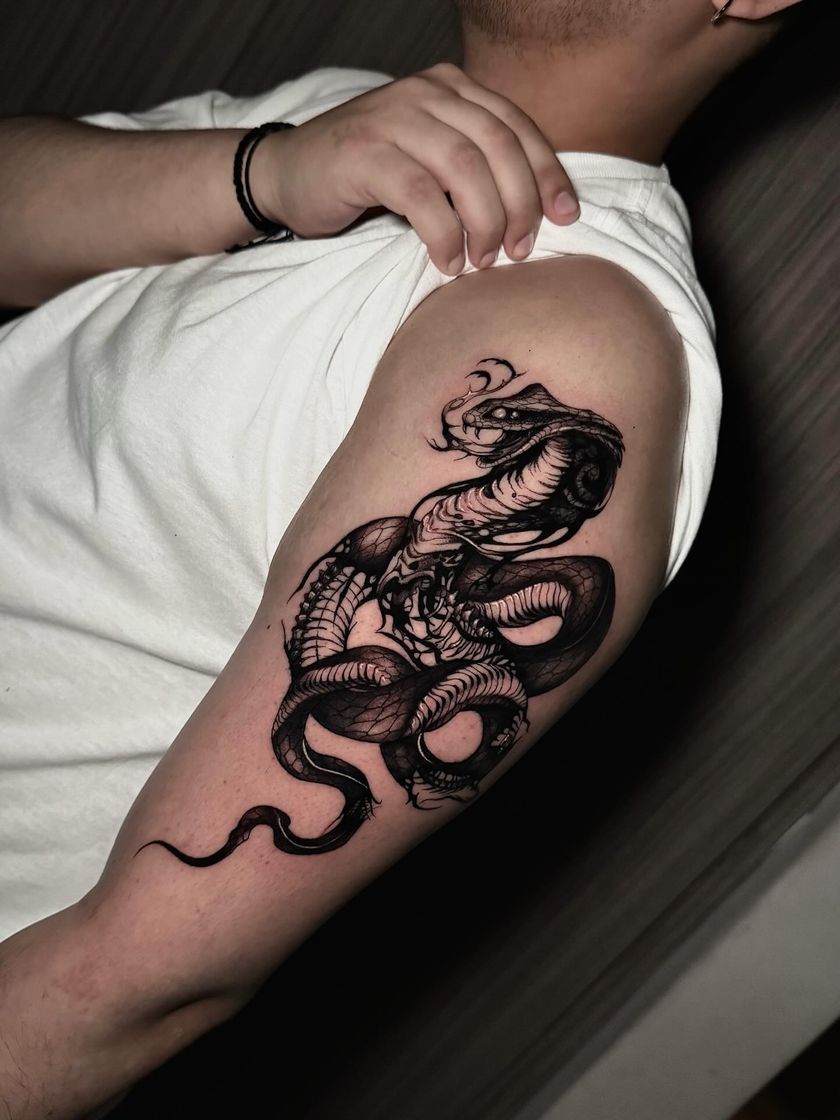 Serpiente enroscada en blackwork sobre el brazo